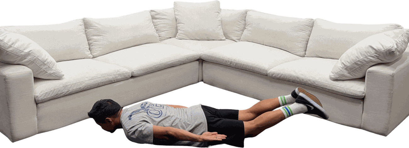 Isaac planking on the floor in front of a white sectional from SD Couch