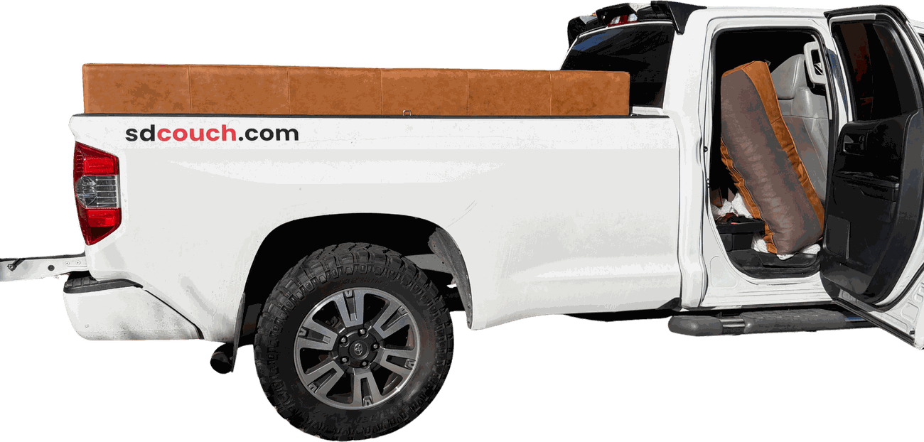 The SD Couch Toyota Tundra loaded with a tan leather sofa, sdcouch.com sticker on the bed